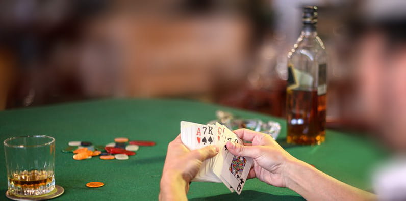 Guy Drinking Whiskey on a Casino Card Games Table