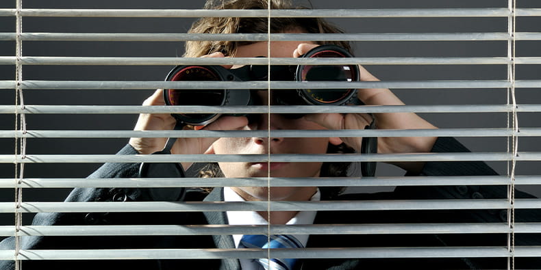 Man Spying Someone with Binoculars From a Window