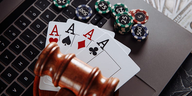 A Judge Gavel, Casino Chips and Cards on a Laptop