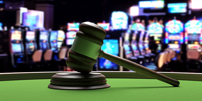 Judge Gavel on a Roulette Table and Slot Machines on Background