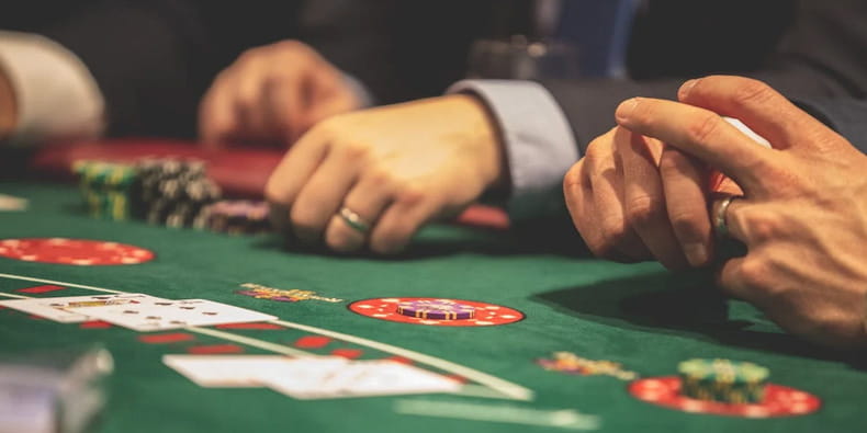 three gentlemen playing blackjack in casino